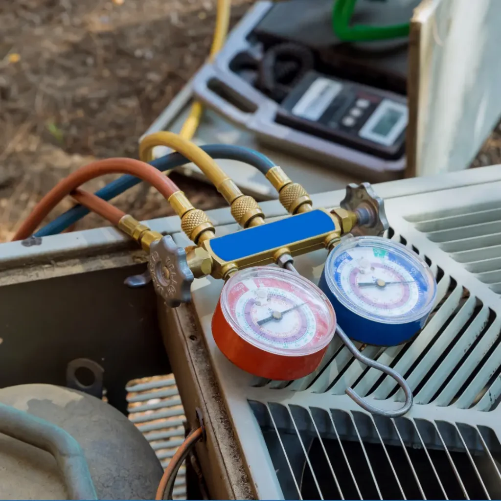 Manifold pressure gauges attached to an outdoor air conditioner unit during AC maintenance service in Northern Virginia.