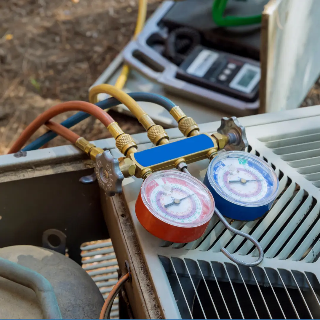 Manifold pressure gauges attached to an outdoor air conditioner unit during AC maintenance service in Northern Virginia.